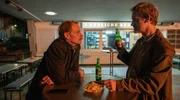 Daniel Kossik (Stefan Konarske, l) und Peter Faber (J&ouml;rg Hartmann, r), unterhalten sich bei einer Currywurst &uuml;ber die Ermittlungen zum Mord an Haller in gewohnt feindseliger Manier.