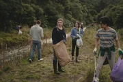 Issie (Macey Chipping, 2.v.r.), Natascha (Antonia Robinson, 2.v.l.) und Caleb (Joshua Tan, r.) helfen den Bewohnern von Kauri Point bei der M&uuml;llsammelaktion. Es ist erschreckend, wie viel M&uuml;ll die Touristen in der Wildnis hinterlassen haben.