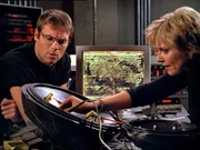 Carter (Amanda Tapping) versucht das demulierte Flugobjekt zusammen zu setzen. Daniel (Michael Shanks) hilft ihr mit seinem &Uuml;bersetzungswissen...