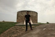 RJ posiert vor dem Tower of Silence (Dakma) in Diu, Indien. Der Tower of Silence ist eine zirkul&auml;re Struktur, die von Zoroastriern genutzt wurde, um Verstorbene freizulegen.