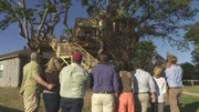Pete Nelson looking at the finished bird nest treehouse with the owners.