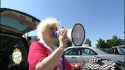 Lauthals und mit einem Megaphon preist die rüstige Lieselotte ihre Waren auf dem Flohmarkt an Lauthals und mit einem Megaphon preist die rüstige Lieselotte ihre Waren auf dem Flohmarkt an