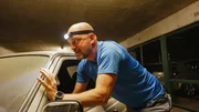 Ralf Gerstenlauer pushes an old Mercedes in an underground car park