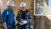 Michael Holmes (left) and Michael Holmes (right) review specs for the build of Patrick and Stokely's basement as seen on Holmes Family Rescue, Season 2.