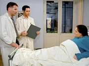 Dr. Brentano (Thomas Koch, mi.) und Dr. Heilmann (Thomas R&uuml;hmann, li.) k&ouml;nnen sich nicht erkl&auml;ren, weshalb Manuelas Blutdruck trotz der blutverd&uuml;nnenden Medikamente nicht sinkt. Doch Manuela (Katrin Filzen, re.) glaubt, dass zwischen Arzu und ihrem Mann etwas l&auml;uft und beschuldigt Arzu, ihr die wichtigen Medikamente nicht gegeben zu haben.