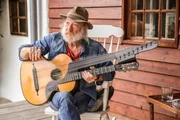 Roland Neuwirth spielt Kontragitarre auf seiner Veranda im Waldviertel