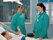 Elena Eichhorn (Cheryl Shepard, re.) erkl&auml;rt dem kleinen Tim (Leo Natalis, li.) und seinem Vater Norbert (Steven Merting, mi.), dass die Operation gut verlaufen ist.