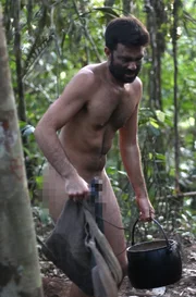 Fernando carries water in the pot as it gets dark outside.