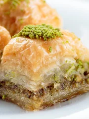Baklava with pistachios and walnuts on white plate. Shallow depth of field
