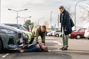 Achim Weishaupt (Torsten Knippertz, liegend) verteilt Flyer f&uuml;r einen k&ouml;lschen Verein auf dem Parkplatz des SOKO-Pr&auml;sidiums. Als Kommissare Matti Wagner (Pierre Besson, l.) und Jonas Fischer (Lukas Piloty, r.) eintreffen, bricht er pl&ouml;tzlich vor ihnen zusammen &ndash; und stirbt.