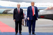Donald Trump (r), Pr&auml;sident der Vereinigten Staaten, begr&uuml;&szlig;t seinen russischen Amtskollegen Wladimir Putin w&auml;hrend einer Zeremonie am Flughafen vor ihrem Treffen auf der Joint Base Elmendorf-Richardson.