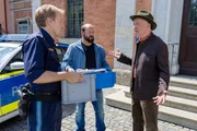 Als Polizeihauptmeister Mohr (Max M&uuml;ller, l.) und Vitzi Huber (Alexander Vitzthum, M.) von der Spurensicherung die beschlagnahmten Gipfelb&uuml;cher des Opfers ins Pr&auml;sidium tragen wollen, verl&auml;sst Wolfram Wenninger (Heinz-Josef Braun, r.) nach seiner Befragung das Geb&auml;ude und m&ouml;chte die B&uuml;cher an sich nehmen.