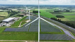 Das Bild zeigt einen hybriden Energiepark, der Sonnenkollektoren und Windkraftanlagen kombiniert.