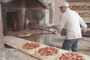 K&ouml;stliches Apulien - Terra di Bari; Giuseppe di Ges&uacute; schiebt Focaccia in den Ofen.