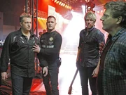 Der Bassist der Band "Rascal Flatts" hat einen heftigen Stromschlag erlitten. Nick (George Eads, 2.v.l.) befragt die Bandmitglieder Gary Levox (l.) und Joe Don Rooney (2.v.r.) und den Techniker Travis (Brent Briscoe), wie es dazu kommen konnte.
