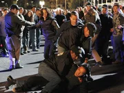 Sara (Jorja Fox, back center) and Nick (George Eads, front center) rush to the scene of a streetcar race while investigating the mysterious death of a high school student and his missing girlfriend.