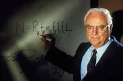 Ansicht des amerikanischen Astronomen Dr. Frank Drake (1944-). Er demonstriert seine &bdquo;Drake-Gleichung&ldquo;, eine Gleichung, die vorhersagt, dass es in unserer Galaxie (der Milchstra&szlig;e) eine Reihe beobachtbarer Zivilisationen gibt. 1960 f&uuml;hrte er die erste Radiosuche nach au&szlig;erirdischen Geheimdiensten durch. Anschlie&szlig;end wurde er Professor f&uuml;r Astronomie an der Cornell University, USA (1964-1984). Drake ist jetzt Pr&auml;sident des SETI-Instituts (Search for Extraterrestrial Intelligence), einer Organisation, die sich der Suche nach intelligenten Funksignalen aus dem Weltraum widmet. Drake gibt SETI die allgemeine Forschungsrichtung vor.