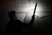 Der Arch&auml;ologe Darius Arya beleuchtet die unterirdischen &Uuml;berreste eines Freskos in der Domus Aurea von Kaiser Nero in Rom.