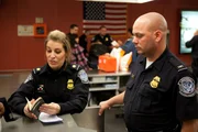 Jamaica, New York, USA: Die Zoll- und Grenzschutzbeamten Corinne Cipoletti und Chris Elias arbeiten zusammen, um einen Reisenden am John F. Kennedy Flughafen zu kontrollieren. (Bildnachweis: National Geographic Television)