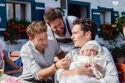 Basti (Raban Bieling, r.) ist gl&uuml;cklicher Patenonkel der kleinen Pauline. Der stolze Vater Schorschi (Sebastian Edtbauer, M.) und Franz (Pablo Sprungala) freuen sich mit ihm.