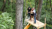 Pete Nelson talking with Brian Kelley and Brittney Marie Cole on the platform at the construction site of the speakeasy-themed treehouse.