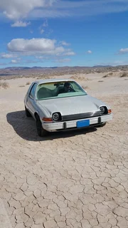 Portrait image, wide shot of AMC Pacer in Nevada Desert, front view.