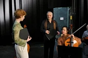 Die Cellistin Kate Chang (Kotti Yun, r.) genie&szlig;t ihre Rolle als neue Favoritin des Dirigenten Justus van Heyden (Bernhard Sch&uuml;tz, M.), vor ihrer Konkurrentin Judith Lange (Sarah Bauerett, l.).