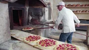 K&ouml;stliches Apulien &ndash; Terra di Bari Giuseppe di Ges&uacute; schiebt Focaccia in den Ofen.