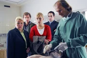 Mark (Siegfried Terpoorten, 2.v.l.) und Rebecca (Lilian Klebow, M.) stehen mit Mayerle (Harry Blank, 2.v.r.) und der Richterin Sch&auml;ffer (Sarah Camp, l.) erstaunt vor der Leiche Georg Wittkes, die obduziert werden soll. Dr. Jahn (Eisi Gulp, r.) findet es allerdings ein bisschen piet&auml;tlos, einem toten Mann so ungeniert auf seine, wenn f&uuml;r einen Toten auch sehr lebendige M&auml;nnlichkeit zu starren ...