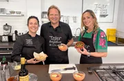 Bj&ouml;rn Freitag und Tamina Kallert (r) beim Tapas-Kochkurs in der Kochschule &ldquo;Taller Andaluz de Cocina&rdquo; im Mercado de Triana &ndash; gemeinsam mit K&ouml;chin Victoria (M) entstehen echte andalusische Klassiker.