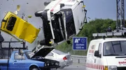 Der VW-Bus der fl&uuml;chtenden Gangster hebt &uuml;ber einem ADAC-Helfer ab. Ein nachfolgender LKW schafft es nicht mehr zu bremsen und crasht in das Ende der Unfallstelle...