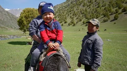 Wer Laufen kann, der kann auch Reiten. Nomadenkinder beim Zeitvertreib auf der Sommerweide.