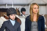 Georgie (Alisha Newton, li.) und Amy (Amber Marshall) beobachten den Ritt von Georgies Konkurrentin Olivia.