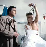 Kriminalkommissar Lenz (Helmut Fischer, links) besucht im Krankenhaus den Amerikanischen Soldaten Burt Baxter (William Mang), auf den ein weiterer Mordanschlag ver&uuml;bt wurde.