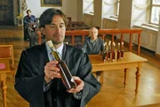 W&auml;hrend Staatsanwalt Mayerle eine flammende Rede gegen den illegalen Schnapsbrenner Laurenz Pirngruber (Gerd Lohmeyer, r.) h&auml;lt, preist Frebert (Robert Lohr, l.) die hervorragende Qualit&auml;t des Magenbitters an und fordert vehement die Wiederbelebung dieses versch&uuml;tteten Kulturguts.