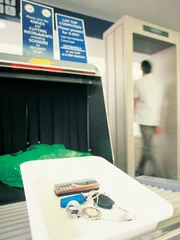 Two People Walking Through a Metal Detector at Airport Security