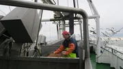 Krabbenfischer Hendrik Dirks arbeitet an Bord seines Kutters auf der Nordsee, w&auml;hrend &uuml;ber dem Wattenmeer die M&ouml;wen kreisen.