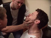 Zwei M&auml;nner bedrohen einen dritten Mann