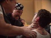 Ein Mann erw&uuml;rgt einen Mann in Anwesenheit von anderen