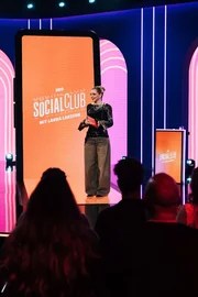 Laura Larsson begr&uuml;&szlig;t das Publikum im Studio ihrer TV-Show "Neo Social Club".