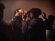 Ein Mann h&auml;lt seine H&auml;nde in die Luft, w&auml;hrend ein anderer Mann ihn bedroht.