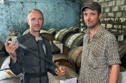 Obstbauer J&eacute;r&ocirc;me Lecrosnier (li.) l&auml;sst von S&eacute;bastien Roullier (re.) mit einer mobilen Destille Calvados brauen.