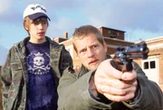 Rainer Goltz (Henning Baum, re.) und sein Sohn Daniel (Robin Becker) konnten sich aus der Gewalt des Gangsters Udo Hesse befreien. Daniel ermahnt seinen Vater nun nicht zum M&ouml;rder zu werden w&auml;hrend der mit einer Waffe auf Hesse zielt.