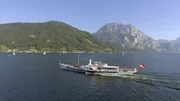 "Sommerfrische - Reisen wie zu Kaisers Zeiten", Das Vielv&ouml;lkerreich der Habsburger stellte einen kulturell wie gesellschaftlich einzigartigen Kosmos dar. Die nostalgische Verkl&auml;rung dieser &Auml;ra begann noch vor dem Ende des Habsburgerreichs und h&auml;lt bis heute an, vor allem in Orten, die mit einer der sch&ouml;nsten Errungenschaften der Donaumonarchie verbunden sind - der Sommerfrische. Das vornehmlich adelige und gro&szlig;b&uuml;rgerliche Sommervergn&uuml;gen, dessen Wurzeln in der Biedermeierzeit liegen und dem - wenn auch in bescheidenerem Rahmen - bis in die Zwischenkriegszeit gefr&ouml;nt wurde, wird in dieser Dokumentation in all seinen Facetten gezeigt: von den popul&auml;rsten Reiseziele vergangener Tage &uuml;ber die spezielle Reisekultur bis zu Transportmitteln und -wegen.Das "Fin de sičcle" wurde zum H&ouml;hepunkt der Sommerfrische. Man reiste mit den Annehmlichkeiten der Stadt aufs Land, um dort wie in einem Freiluftsalon die Vorz&uuml;ge von gut gepflegter Natur und urbaner Geselligkeit miteinander zu verbinden. Man schw&auml;rmte von Triest, von der Riva in Pola und vom milden Klima Abbazias.  Damals entdeckte man den Lago di Garda, den W&ouml;rthersee und eroberte die Gipfel der Alpen. Das Reisen im alten &Ouml;sterreich war untrennbar mit der verkehrstechnischen Erschlie&szlig;ung des Gro&szlig;reichs verbunden. Das  Salzkammergut gilt als Wiege der Sommerfrische. Der Kurbetrieb am Traunsee war zutiefst verbunden mit dem &ouml;sterreichischen Kaiserhaus und der N&auml;he zu Ischl, wo Kaiser Franz Joseph seine Sommer verbrachte. Bis heute konnten Orte wie Gmunden viel vom Flair vergangener Tage bewahren. W&auml;hrend am Traunsee &uuml;berwiegend  Mitglieder der nationalen und internationalen Aristokratie dominierten, wurde das restliche Salzkammergut bald durch das gehobene B&uuml;rgertum erschlossen. Mitte des neunzehnten Jahrhunderts entdeckte man den Attersee und die ersten Sommervillen der Bourgeoisie entstanden. Fasziniert vom T&uuml;rkisblau des Wassers am Attersee mischten sich Fotografen,  Maler, Komponisten und Dichter - von Gustav Mahler bis Gustav Klimt -unter das reiche Gro&szlig;b&uuml;rgertum. In der 1890 erbauten Villa Langer in Steinbach am Attersee wird die Sommerfrische wiederbelebt, wie sie Adelige, Gro&szlig;b&uuml;rger und ber&uuml;hmte K&uuml;nstler genossen haben.Wenn Komponisten Urlaub machten,  suchten sie meist nach Inspiration und Ruhe. Als kreative Refugien dienten ihnen gerne Seeb&auml;der, Komponier-H&auml;uschen oder ein abgelegenes Waldhaus. Gerne bedienten sie dabei das Klischee des genialen Eremiten, auch wenn so mancher von ihnen den Freuden des Lebens nicht abgeneigt war. Johannes Brahms war einer jener Komponisten, die ihre produktivsten Zeiten w&auml;hrend ihres Urlaubs hatten. Sommerfrische war f&uuml;r ihn niemals nur Am&uuml;sement. Einige seiner ber&uuml;hmtesten Werke komponierte er in P&ouml;rtschach am W&ouml;rthersee. Mit dem Anschluss der Bahnstrecke Wien-Klagenfurt an die "k.u.k. S&uuml;dbahn" wurde der Aufenthalt am W&ouml;rthersee zu einer gut erreichbaren Attraktion und P&ouml;rtschach zu einem der edelsten Sommerfrische-Orte in der Donau-Monarchie. Die Sommerfrische - der Historiker Hanns Haas nennt sie eine "verlorene touristische Kulturform" - war keine "Verabredung mit dem Fremden", sondern bot Kontinuit&auml;t und bezog ihren Reiz aus der Wiederkehr des Vertrauten. Wo fr&uuml;her mond&auml;nes Leben und zeitgem&auml;&szlig;er Chic dominierten, begegnet uns heute mitunter nur noch milde Patina. Aber es gibt sie noch, die Orte und Landschaften, wo trotz zeitgem&auml;&szlig;er Technik versucht wird, das Flair vergangener Tage zu erhalten. Dieses Flair gilt es zu ersp&uuml;ren und zu ergr&uuml;nden, um den Mythos der Sommerfrische erfahrbar zu machen.Eine Dokumentation von Bj&ouml;rn K&ouml;lz und Gernot StadlerIm Bild:  SENDUNG: ORF2 - SO - 12.07.2020 - 09:05 UHR. - Veroeffentlichung fuer Pressezwecke honorarfrei ausschliesslich im Zusammenhang mit oben genannter Sendung oder Veranstaltung des ORF bei Urhebernennung.