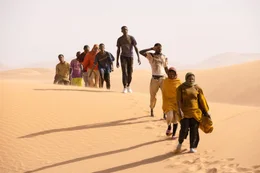 Trotz hoher Transportkosten muss die Reisegruppe um Seydou (Seydou Sarr, 4.v.r.) die Sahara  schutzlos zu Fu&szlig; durchqueren.