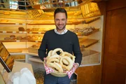 Hoagascht Moderator Richard Deutinger h&auml;lt Korb mit Fastenbrezen in der B&auml;ckerei Binggl.