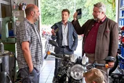 Die Kommissare Hansen (Igor Jeftic, M.) und Stadler (Dieter Fischer, r.) befragen den Besitzer einer Motorradwerkstatt, Bernhard "Bulli" Kuhn (Hannes Ringlstetter, l.), denn das Mordopfer war sein Kunde.