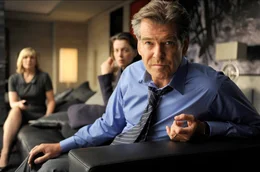 Ein Ghostwriter, der die Memoiren eines ehemaligen britischen Premierministers fertigstellen soll, enth&uuml;llt Geheimnisse, die sein eigenes Leben in Gefahr bringen. - Lang (Pierce Brosnan, r.) erf&auml;hrt zusammen mit seiner Frau Ruth (Olivia Williams, Mitte) und seiner Assistentin Amelia (Kim Cattrall, l.) aus den Nachrichten, dass gegen ihn wegen Kriegsverbrechen w&auml;hrend des Irakkrieges ermittelt wird.