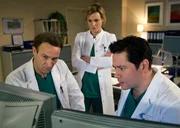 Roland Heilmann hat die erste OP &uuml;berstanden, doch die abgebrochene Messerspitze sitzt nahe am R&uuml;ckenmark und k&ouml;nnte jederzeit wandern. Rolands Werte sind jedoch so schlecht, dass er momentan keine weitere OP &uuml;berstehen w&uuml;rde. Dr. Lea Peters (Anja Nejarri, Mitte), Dr. Martin Stein (Bernhard Bettermann, links) und Dr. Philipp Brentano (Thomas Koch) &uuml;berlegen, wie sie weiterverfahren k&ouml;nnen.