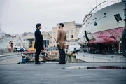 Luca (Lino Guanciale, l.) trifft seinen besten Freund Stefano (Fausto Sciarappa, r.) im Au&szlig;enbereich der Werft.